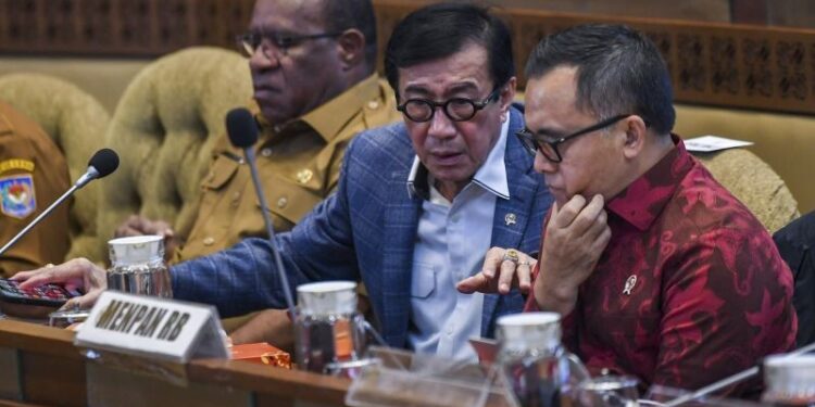 Menteri Hukum dan Hak Asasi Manusia Yasonna Laoly (tengah) bersama Menteri Pendayagunaan Aparatur Negara dan Reformasi Birokrasi (PAN-RB) Abdullah Azwar Anas (kanan) serta Wakil Menteri Dalam Negeri John Wempi Wetipo (kiri) mengikuti rapat kerja dengan Komisi II DPR di Kompleks Parlemen, Senayan, Jakarta, Selasa (26/9/2023).