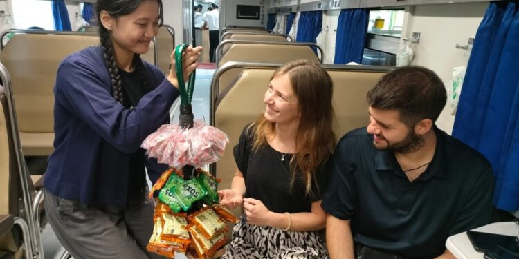 Seorang Pramugari Kereta menjajakan Jajanan dengan Nuansa Pedagang Asongan. Sumber: KAI