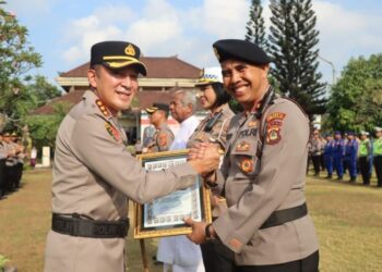 Kepala Kepolisian Resor Kota Denpasar Komisaris Besar Polisi Bambang Yugo Pamungkas (kiri) memberikan penghargaan kepada personel yang dinilai berprestasi di Denpasar, Bali, Selasa (3/10/2023).