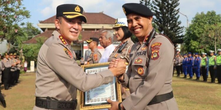 Kepala Kepolisian Resor Kota Denpasar Komisaris Besar Polisi Bambang Yugo Pamungkas (kiri) memberikan penghargaan kepada personel yang dinilai berprestasi di Denpasar, Bali, Selasa (3/10/2023).